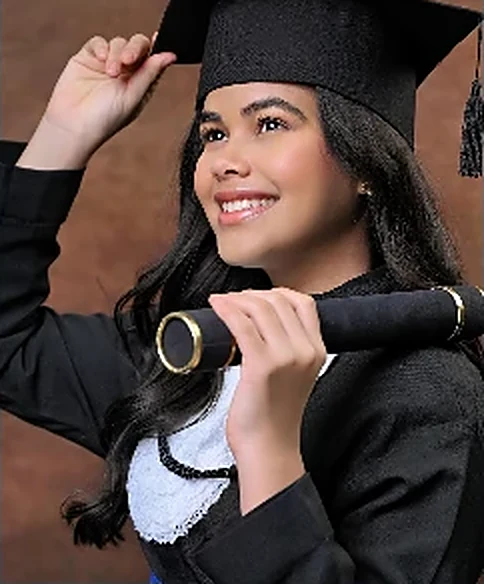 Kaylane Camily de beca e capelo, segurando o canudo na formatura.