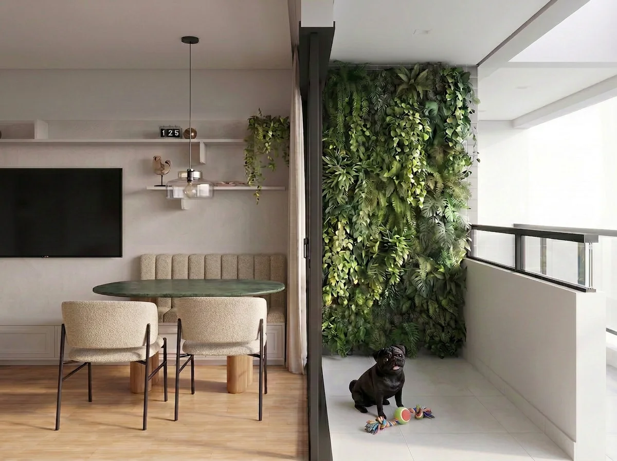 Living e jantar com jardim vertical na varanda, mesa redonda de pedra verde, cadeiras em bouclé e piso de madeira; um cachorro preto sentado na varanda.